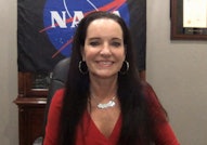 Smiling woman with a NASA flag in the background.