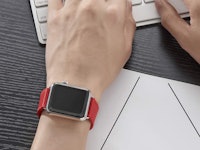 apple watch with bright red band on person typing on keyboard