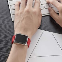 apple watch with bright red band on person typing on keyboard