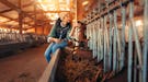 Young woman kissing a goat on a farm in need of farm captions for Instagram.