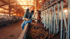 Young woman kissing a goat on a farm in need of farm captions for Instagram.