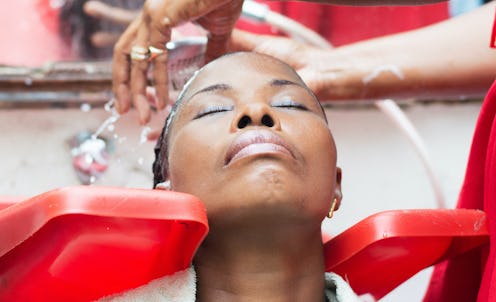 Woman having her hair rinsed at a sink.