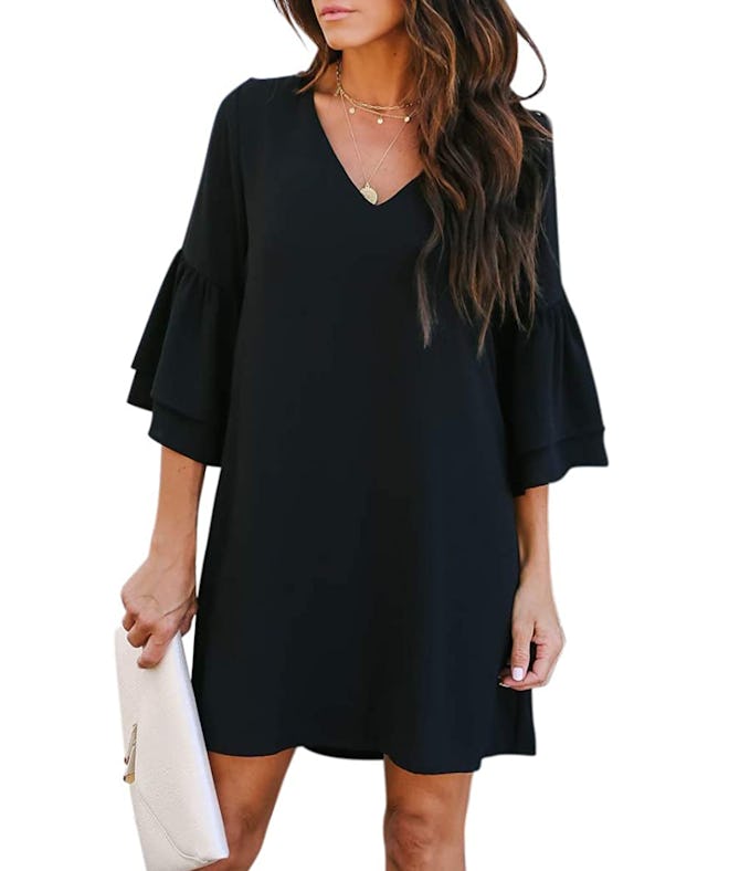 Woman modeling knee-length black dress with 3/4 length bell sleves