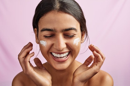 Woman applying face sunscreen