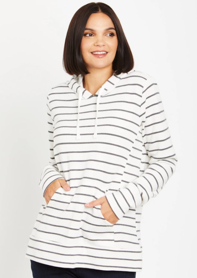 Woman standing, modeling white hoodie with grey stripes