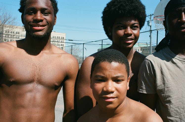 Photograph by Mayan Toledano of boys at a basketball court smiling to the camera 