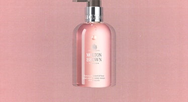 a bottle of Molton Brown's rhubarb and rose hand soap against a pink background