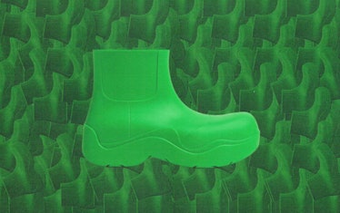 a lime green rubber ankle boot designed by bottega veneta against a textured green background