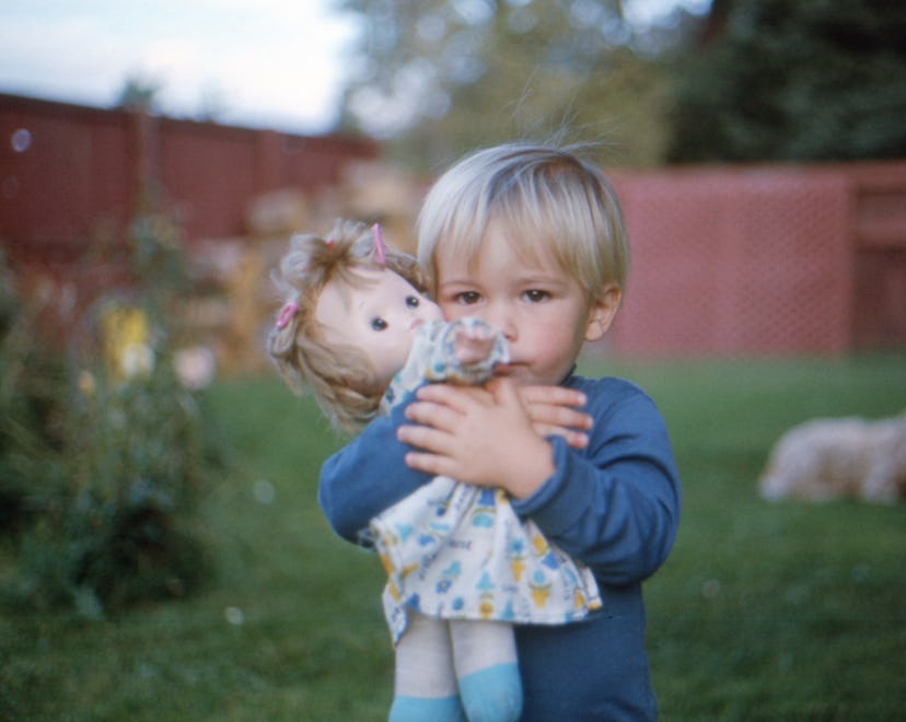 blond baby boy holding a doll