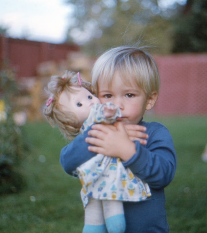 blond baby boy holding a doll