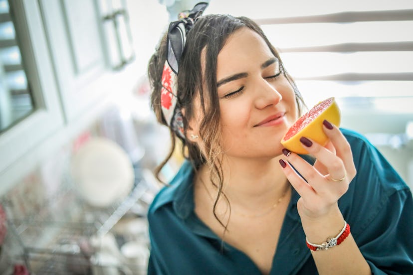 Young woman eating grapefruit to show whether certain foods can change how your vagina tastes.