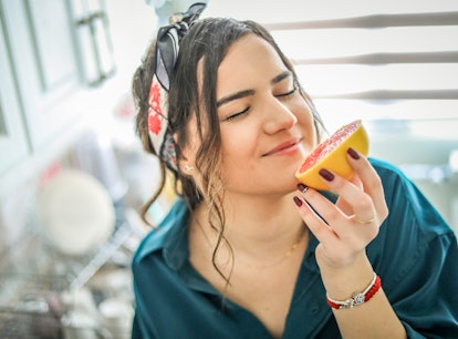 Young woman eating grapefruit to show whether certain foods can change how your vagina tastes.