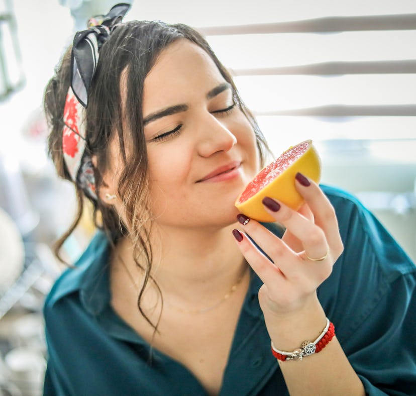 Young woman eating grapefruit to show whether certain foods can change how your vagina tastes.