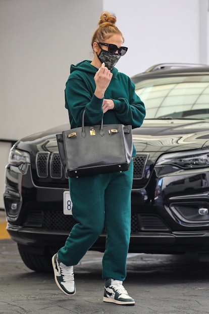 Jennifer Lopez wears matching emerald green sweatshirt and sweatpants from Les Tien in Beverly Hills...