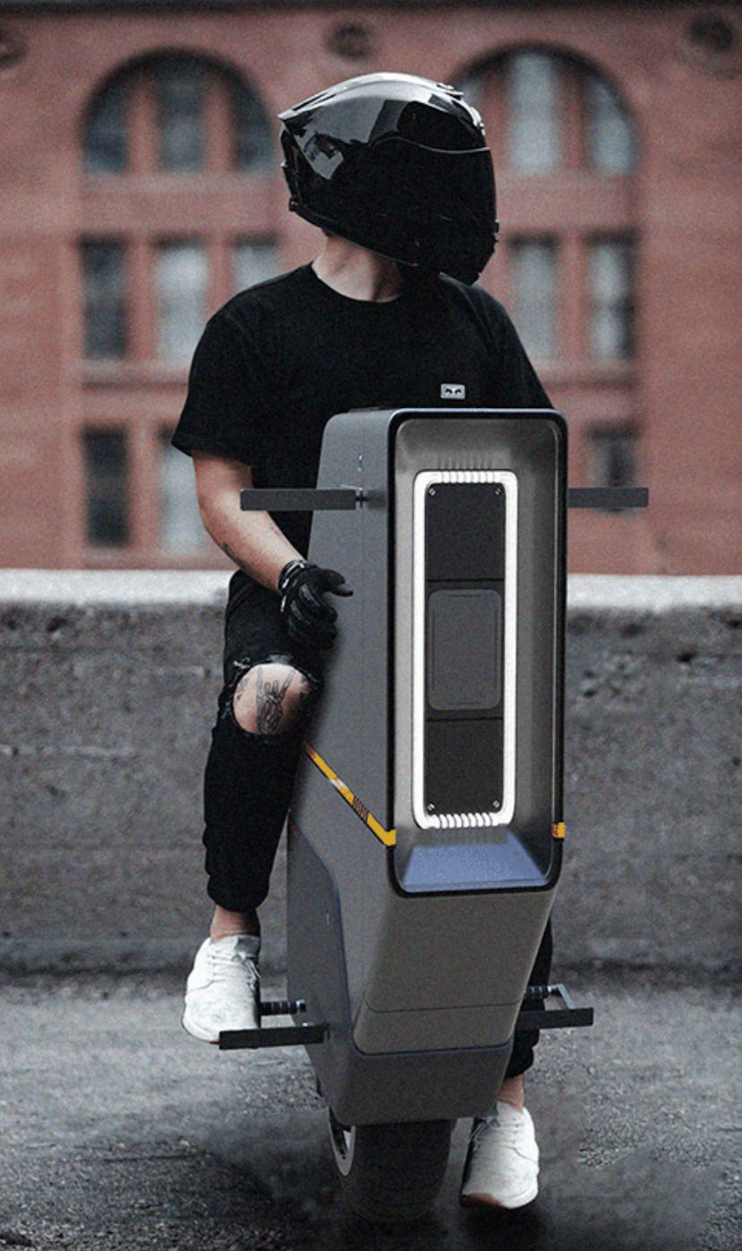 A person sits on the BAIKU vehicle wearing a black helmet. EV. Electric vehicles. EVs.