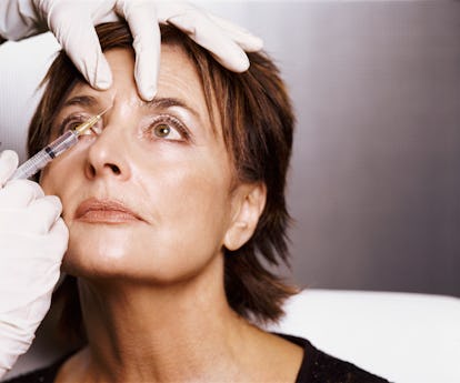 Older woman receiving Botox injection in forehead