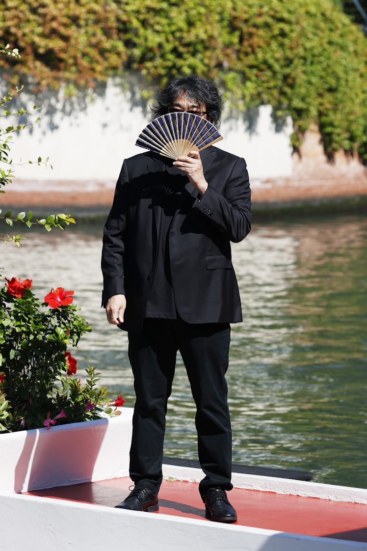 Bong Joon-ho holding a fan in front of his face
