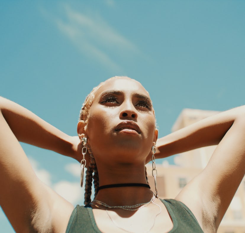 Young woman looking up at the sun ahead of the September 2021 full moon in Pisces, which has a beaut...