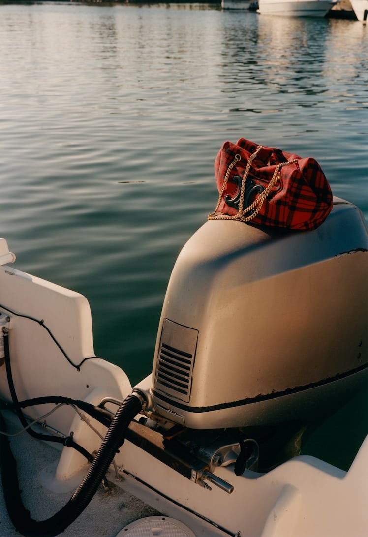Celine by Hedi Slimane bag on an outboard motor of a boat