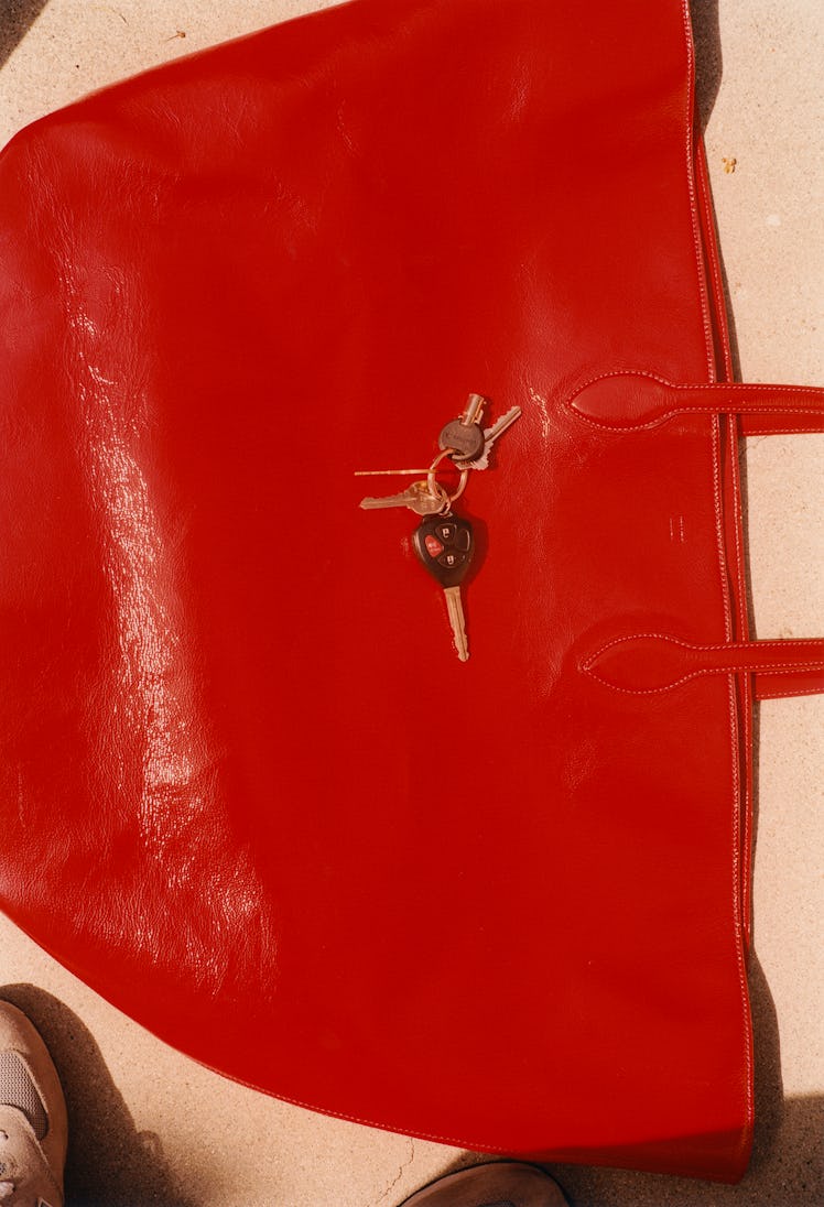 A red Khaite bag with keys on top of it
