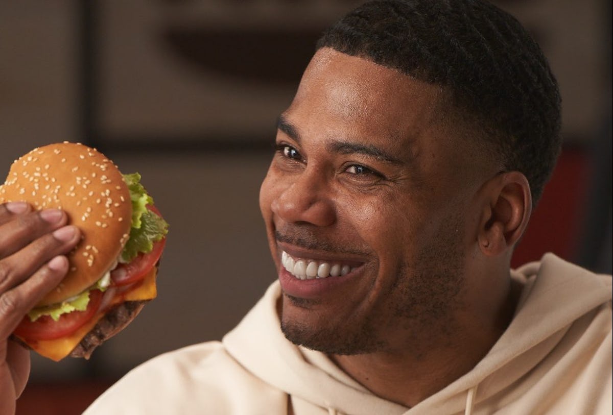 Nelly holding a burger in his hands.