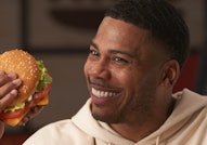 Nelly holding a burger in his hands.