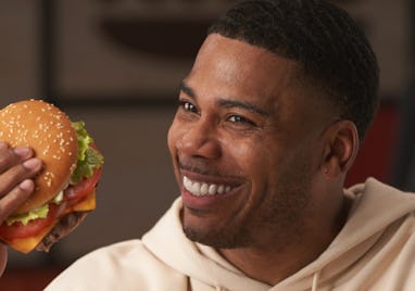 Nelly holding a burger in his hands.