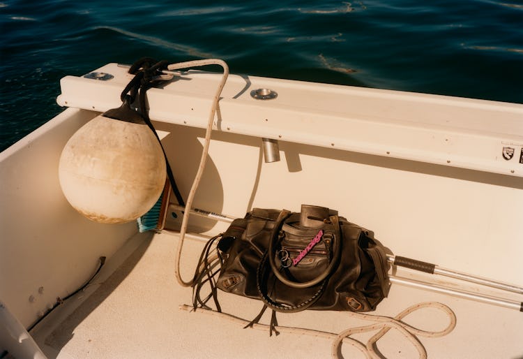 A black Balenciaga bag on the deck of a boat