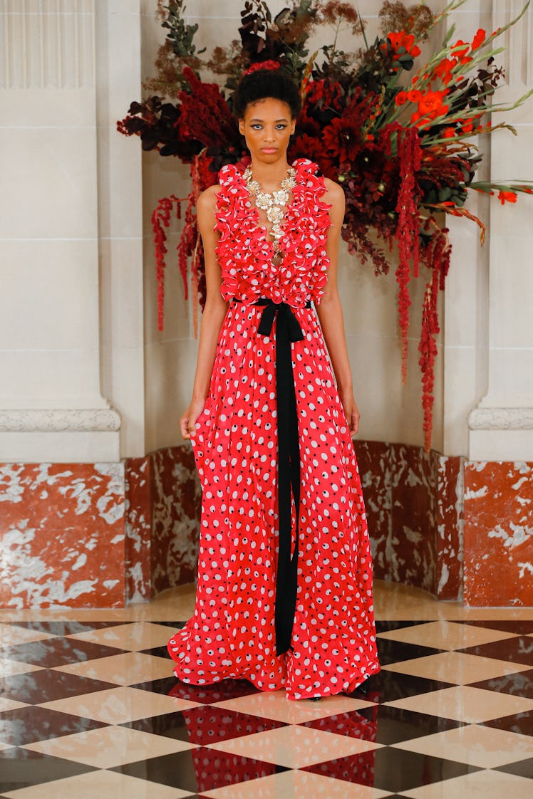A model walking the runway in a red patterned dress by Carolina Herrera during the NYFW Spring 2022