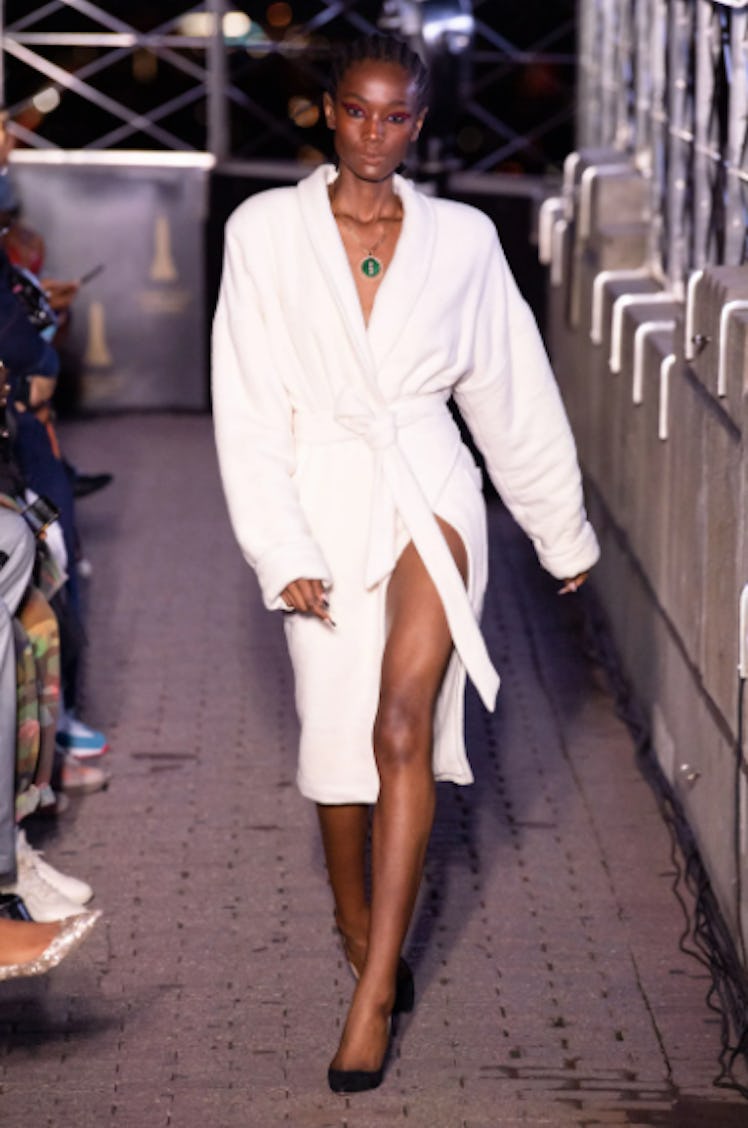 A model walking the runway in a white robe dress by LaQuan Smith during the NYFW Spring 2022