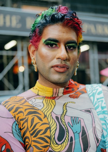 Person wears colorful hair and patterned top.