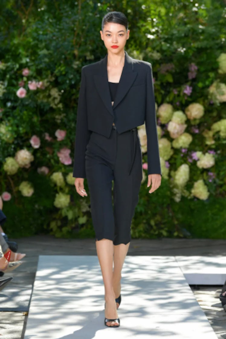 A model walking the runway in a black suit from Michael Kors Collection during the NYFW Spring 2022