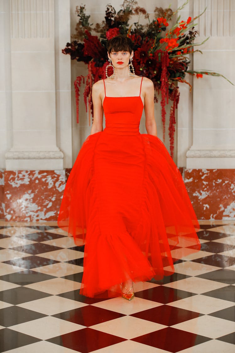 A model walking the runway in a long red dress by Carolina Herrera during the NYFW Spring 2022