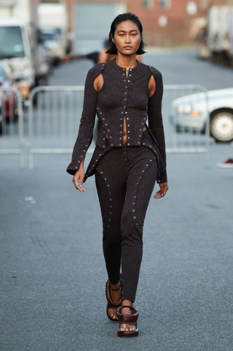 A model wearing a black cut-out suit with studs by Eckhaus Latta during New York Fashion Week Spring...