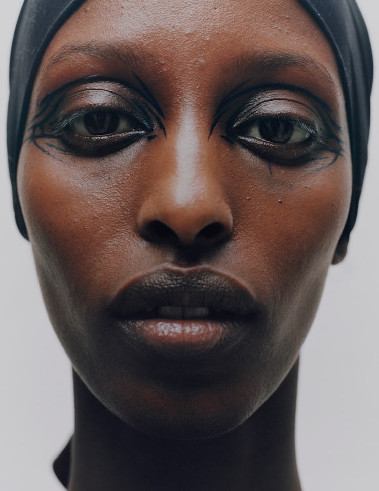 Model Yasmin Kakané's eye look of inky black eye shadow mixed with water and fine lines around the e...