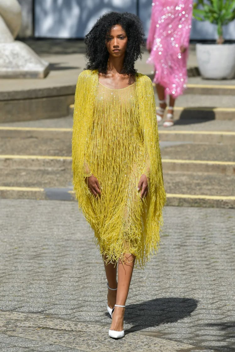 A model wearing a yellow feather dress by Rodarte during New York Fashion Week Spring 2022