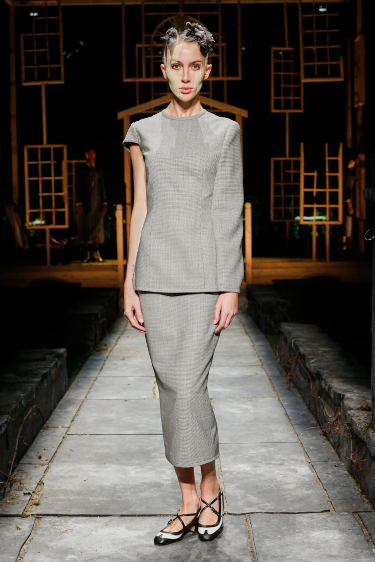 A model wearing a grey set by Thom Browne during New York Fashion Week Spring 2022