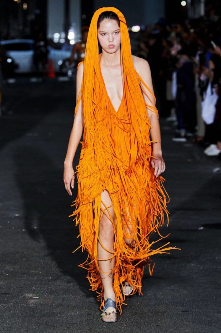 A model wearing an orange fringed Vaquera dress during New York Fashion Week Spring 2022