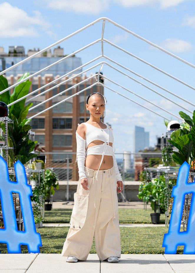 A model in a piece from Tombogo's "Nature Is Healing": a white layered crop top and beige low-rise c...