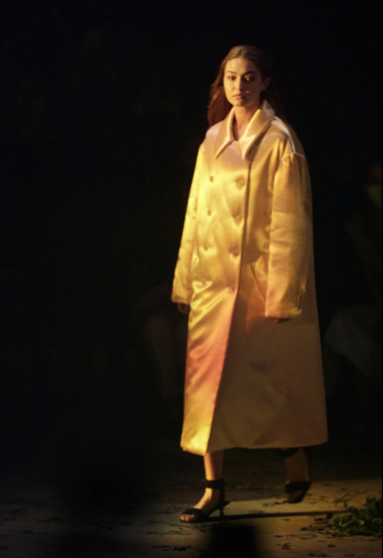 A model wearing an orange satin coat by Khaite during New York Fashion Week Spring 2022