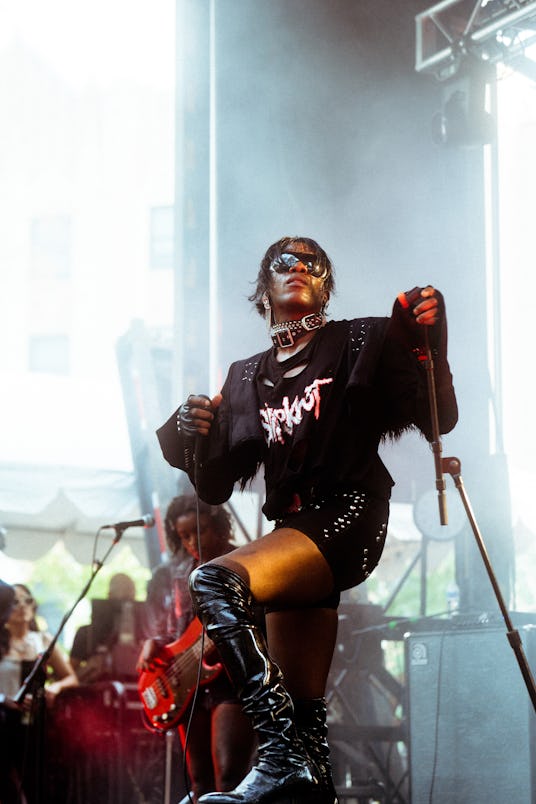 Alexa Viscius holding a microphone and performing at the pitchfork music festival