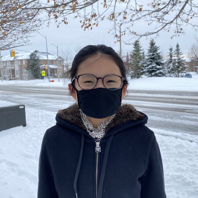 child outside in snow wearing a black kids face mask from Threads