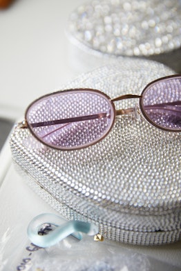 Small purple sunglasses on a silver purse