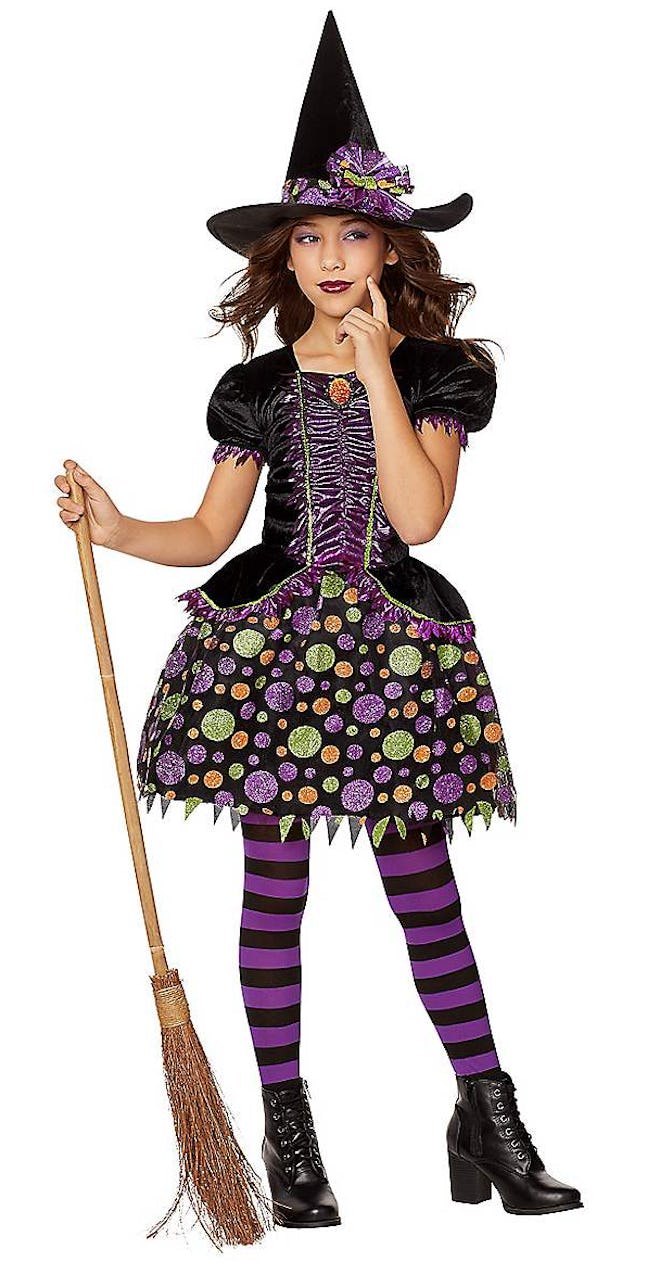 Young girl posing in witch Halloween costume