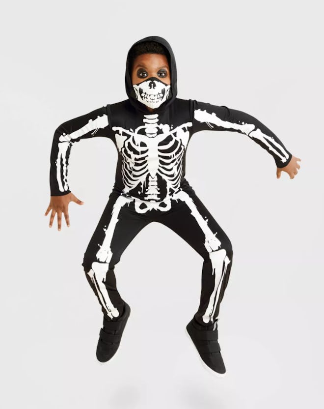 Boy jumping, wearing skeleton costume
