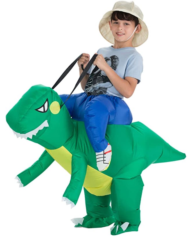 Little boy wearing a costume that makes it look like he's riding a dinosaur