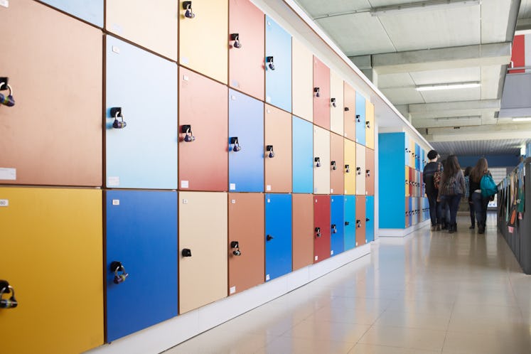 Students seen at the end of a long hallway lined with lockers