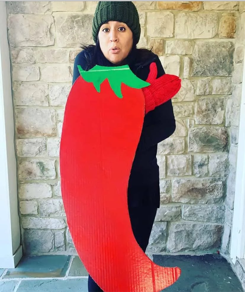 DIY "chilly" pepper costume feature a cardboard chili and a woman in warm clothes, hat, and gloves