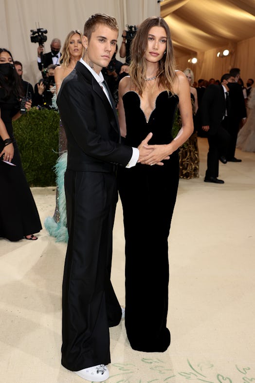 Justin Bieber puts his hand on Hailey Baldwin's stomach as they attend The 2021 Met Gala Celebrating...