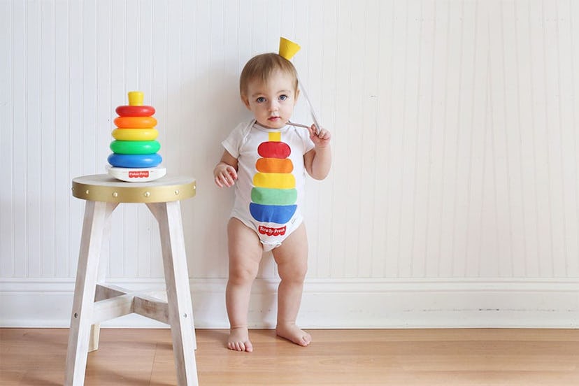 A baby wearing a onesie painted to look like a Fisher Price stacking toy